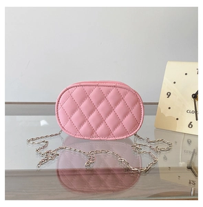 Close-up of pink quilted oval crossbody bag with a fine silver chain strap for kids