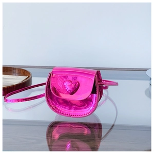 Close-up of a mini heart-shaped crossbody bag in pink patent leather with 3D heart detail