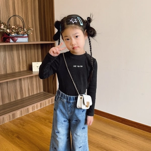 Mini heart chain crossbody bag for girls paired with a casual knitted top and denim pants
