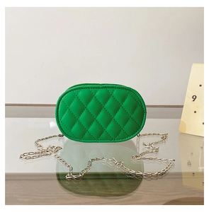 Detail of green oval crossbody bag with classic quilted stitching and silver chain