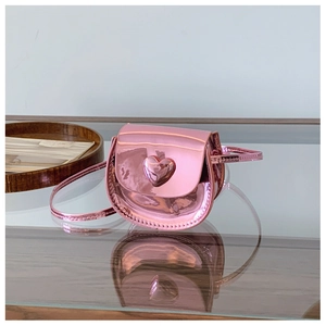 Detail shot of heart-shaped mini crossbody bag in metallic pink leather with chain strap