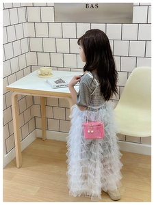 Close-up of pink glitter mini chain bag paired with grey top and layered lace mesh skirt