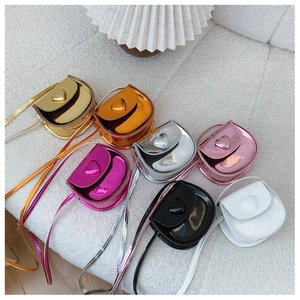 Macro shot of colorful mini heart crossbody bags in glossy patent leather finishes