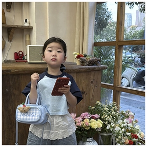 Detail of light blue checkered kids crossbody bag featuring cute bear and TochaSo embroidery