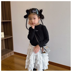 Tenue de mode pour fille avec haut noir à manches longues et jupe en dentelle blanche à étages
