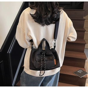 Détail du sac seau noir en nylon avec cordon de serrage et étiquette orange