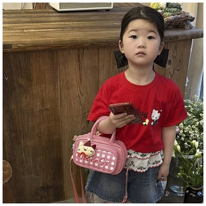 Detailed close-up of a pink checkered kids handbag featuring a cute plush animal patch