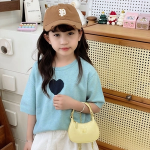 Ensemble fille avec haut en tricot bleu clair, sac à chaîne jaune, casquette et jupe blanche