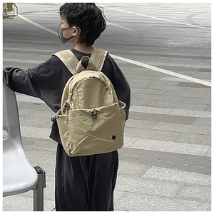 Close-up of khaki waterproof nylon backpack with drawstring side pockets and zip compartments