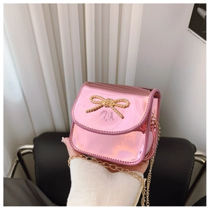 Détail du mini sac rose métallisé avec nœud doré décoratif et bandoulière chaîne