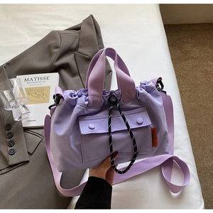 Vue détaillée du sac seau en toile violette avec cordon de serrage et étiquette orange