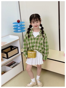 Girl wearing yellow sequin mini crossbody bag with a plaid shirt and white pleated skirt