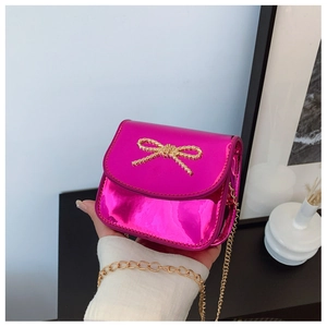 Détail du sac à bandoulière rose métallisé avec boucle nœud dorée et bandoulière chaîne