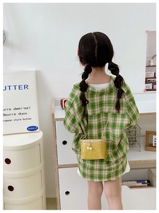 Girl wearing a sparkling gold sequin mini crossbody bag with pearls and chain strap