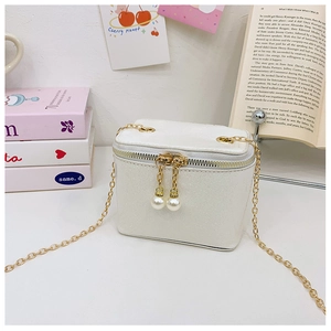 Detail of glitter vanity bag with golden chain strap and pearl zipper charms