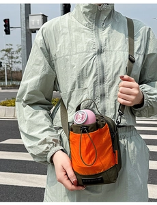Détail du sac bandoulière olive et orange avec poche à cordon pour bouteille d'eau