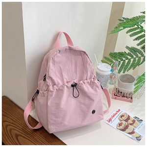 Pink minimalist backpack featuring side zipper pocket and front drawstring storage pocket