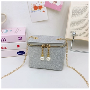 Close-up of silver sequin mini crossbody bag with gold chain and pearl zipper pulls