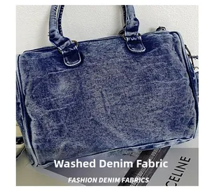 Detail of washed blue denim shoulder bag with vintage bronze hardware and stitching