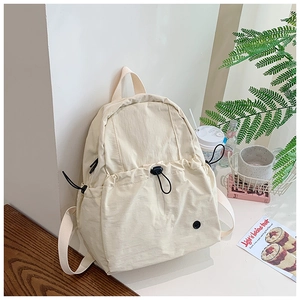 Detail view of cream-white waterproof backpack with large drawstring pocket and side compartments