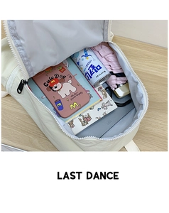 Interior view showing the spacious main compartment of the cream-colored school backpack