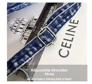 Detail view of the adjustable denim shoulder strap with a silver metal square buckle