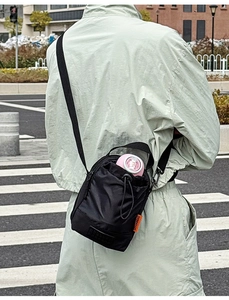 Gros plan extérieur d'un sac porte-bouteille en nylon noir avec étiquette orange vive