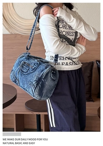 Detailed view of vintage washed blue denim shoulder bag on a model in a cafe setting
