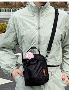 Détail du sac à gourde noir compact avec cordon de serrage et étiquette orange vive