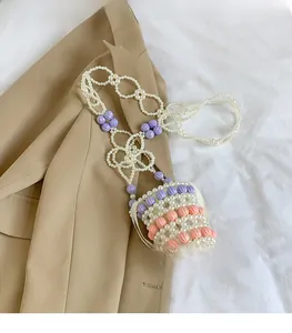 Détail du mini sac bandoulière en perles fait main avec accents floraux roses et violets