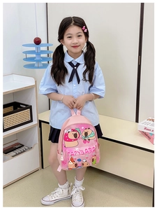 Sac à dos rose pour enfants avec motif capybara, porté par un modèle en intérieur