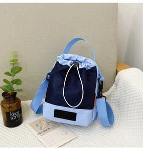 Vue détaillée d'un sac seau bleu en nylon avec cordon de serrage et bandoulière réglable