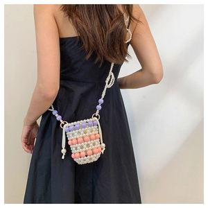 Détail d'un sac bandoulière fait main avec perles blanches et perles citrouilles colorées