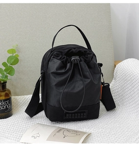 Détail d'un sac seau noir à cordon avec tissu durable et bandoulière réglable