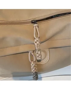 Detail of khaki nylon bag showing the extended woven zipper pull and smooth zip mechanism