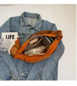 Vue intérieure du grand sac bandoulière en toile orange montrant le compartiment spacieux