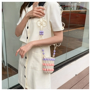 Détail d'un sac à bandoulière en perles fait main avec accents roses et nœud en perles chic