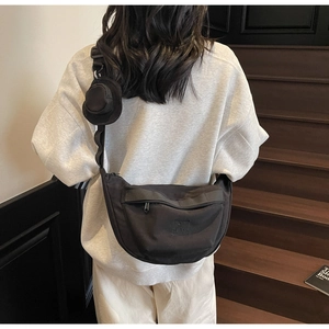 Détail du sac demi-lune noir en toile avec bandoulière réglable et mini porte-monnaie