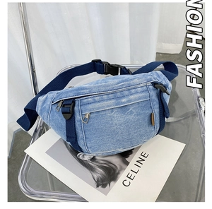 Detailansicht der blauen Denim-Gürteltasche mit Silberreißverschlüssen und Webriemen