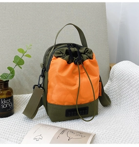 Vue détaillée du sac à cordon vert olive et orange avec bandoulière réglable