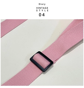 Detail of pink woven shoulder strap with black plastic adjuster for kids barrel bag