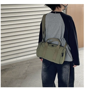 Army green nylon cylinder crossbody bag shown on model for street style look