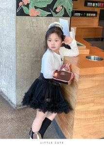Dettaglio della mini borsa in vernice rosa con outfit alla moda in tulle per bambine