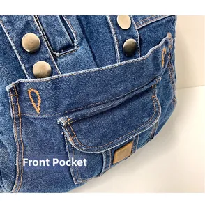 Detail of blue denim backpack featuring front pocket with metal buttons and orange stitching