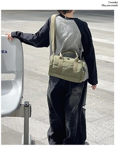 Olive green nylon cylinder crossbody bag for kids featuring adjustable wide strap and logo