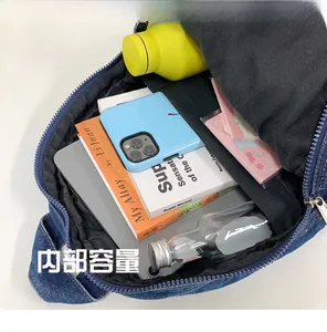 Top view of the interior capacity of a denim backpack showing books and daily items