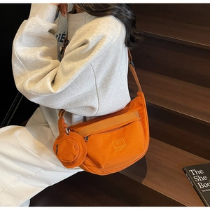 Détail du sac bandoulière en toile orange avec petit porte-monnaie et sangle en nylon