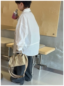 Kids casual street style featuring a beige canvas cylinder bag and loose fit outfit