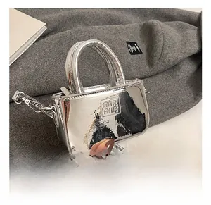 Dettaglio della mini borsa in pelle verniciata argento metallizzato con logo a rilievo
