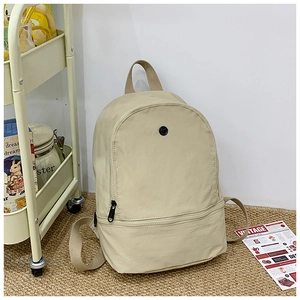 Detail of minimalist cream kids backpack in nylon with double zippered compartments